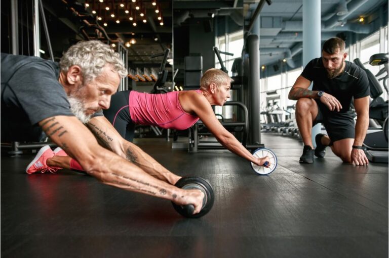 Man and woman using roller for working out abdominals