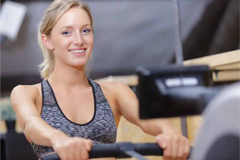 woman athlete exercising on rowing machine